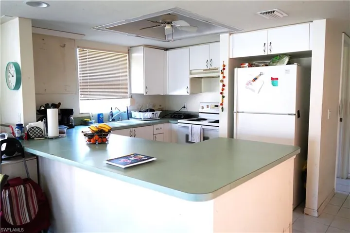 Kitchen featuring ceiling fan, white cabinetry, white appliances, and kitchen peninsula