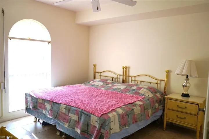 Tiled bedroom featuring ceiling fan