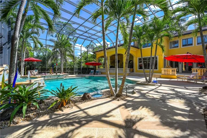Swimming pool featuring a patio, glass enclosure, and a hot tub
