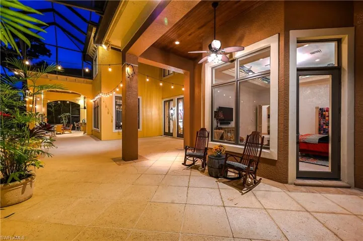 Patio at twilight featuring a ceiling fan, a patio area, and a lanai