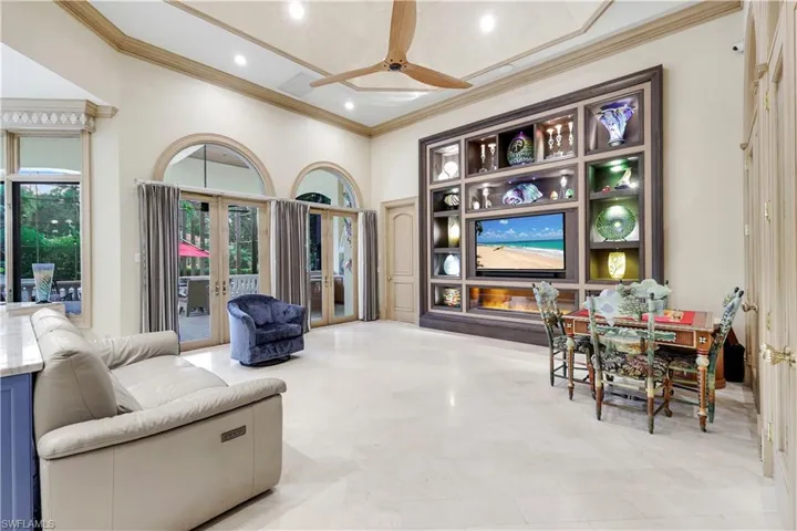 Living area featuring french doors, ceiling fan, crown molding, and recessed lighting