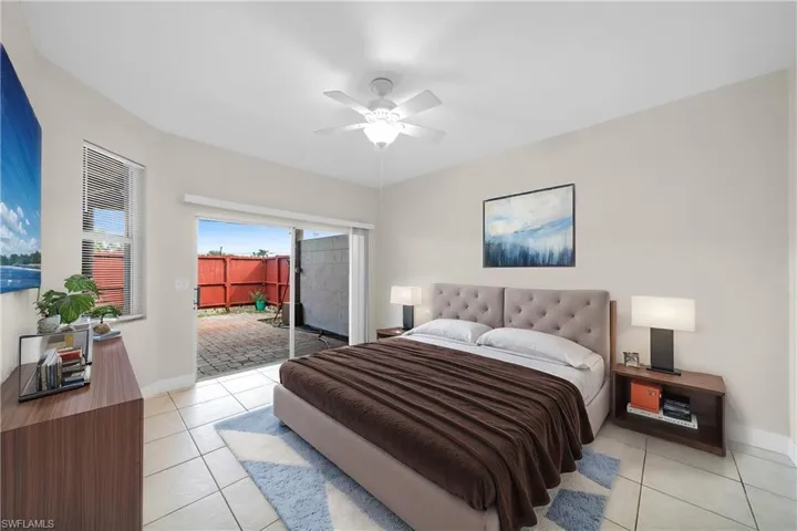 Bedroom with access to outside, light tile patterned flooring, ceiling fan, and baseboards