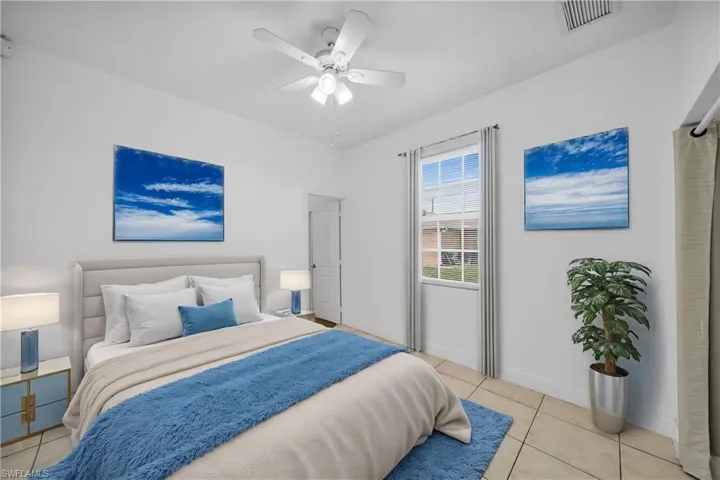Bedroom with baseboards, visible vents, a ceiling fan, and light tile patterned flooring