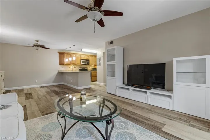 Living room featuring ceiling fan, light hardwood / wood-style flooring, and sink