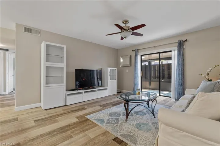 Living room with ceiling fan and light hardwood / wood-style flooring