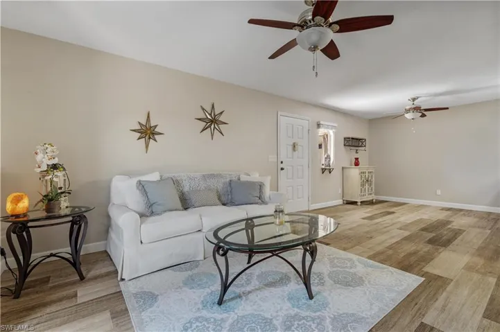 Living room featuring wood-type flooring and ceiling fan