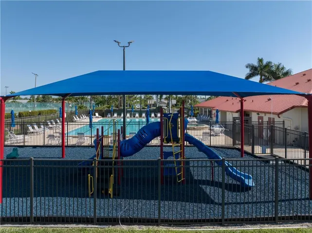 View of jungle gym featuring a community pool