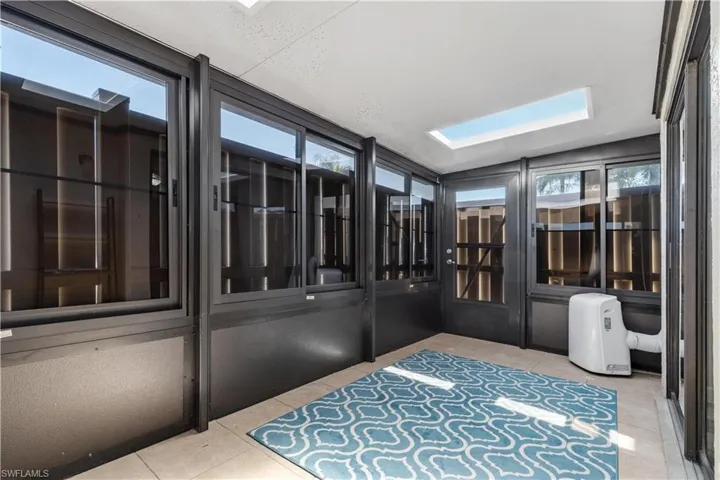 Unfurnished sunroom with plenty of natural light and a skylight