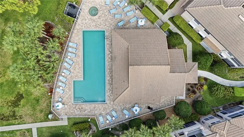 Resort-style pool area featuring a rectangular pool with integrated steps, a circular spa, and a paver deck