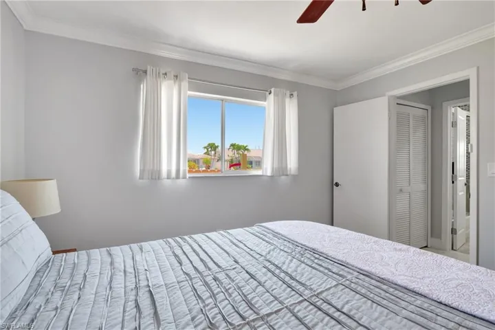 Bedroom with ornamental molding, a closet, and ceiling fan
