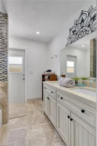 Bathroom featuring tile patterned flooring, a healthy amount of sunlight, and vanity