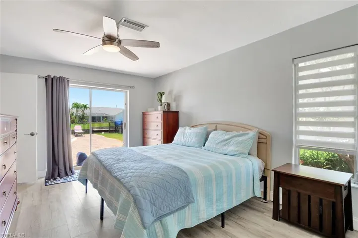 Bedroom with light hardwood / wood-style flooring, ceiling fan, and access to exterior