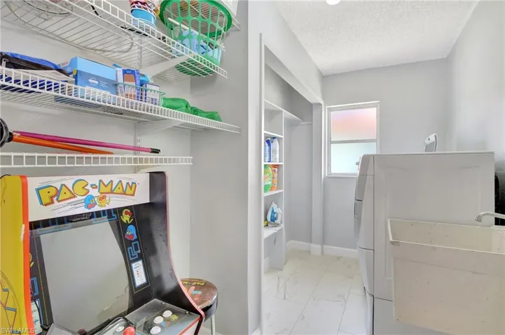 Laundry area featuring washer and clothes dryer, a textured ceiling, and light tile patterned floors