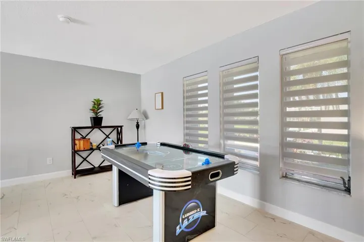 Rec room featuring light tile patterned floors and plenty of natural light