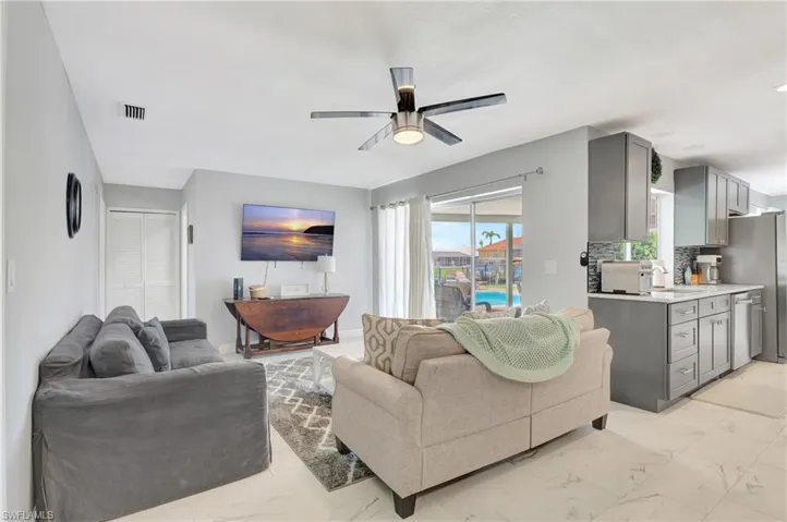 Living room featuring sink, light tile patterned floors, and ceiling fan