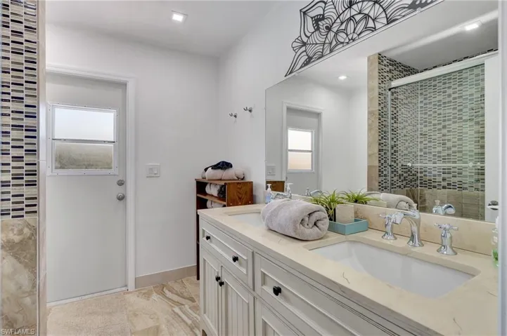 Bathroom with tile patterned floors and double sink vanity