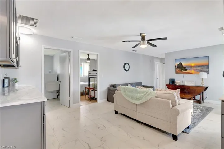 Living room with light tile patterned floors and ceiling fan