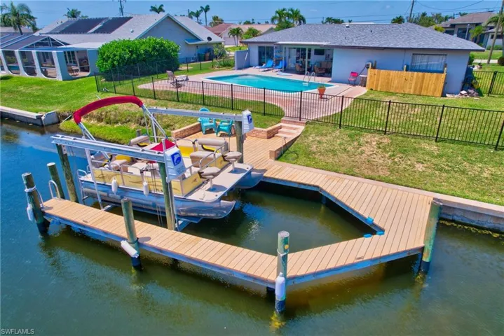 View of dock featuring a lawn and a fenced in pool