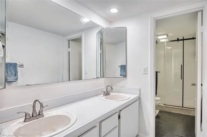 Full bathroom featuring a stall shower and double vanity