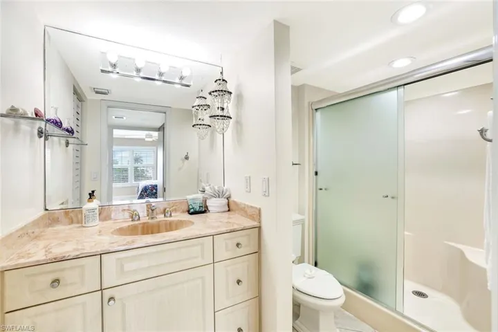 Full bathroom featuring vanity, ensuite bathroom, and a stall shower