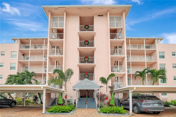 View of apartment building / complex with stairs and covered parking