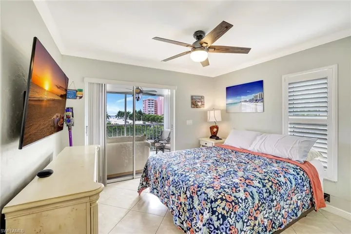 Bedroom with access to outside, light tile patterned flooring, a ceiling fan, and ornamental molding