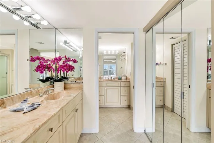 Bathroom featuring vanity, a closet, and light tile patterned floors