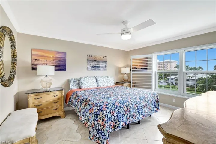 Bedroom featuring ceiling fan, crown molding, and light tile patterned floors