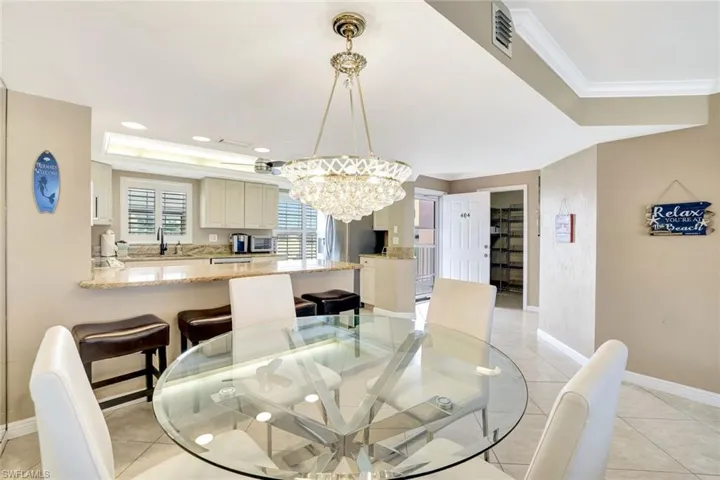Dining area featuring a chandelier, light tile patterned flooring, and ornamental molding