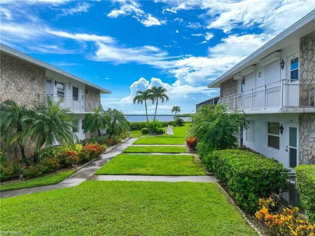 Landscaped courtyard leading toward the waterfront, showcasing the community's tropical setting.