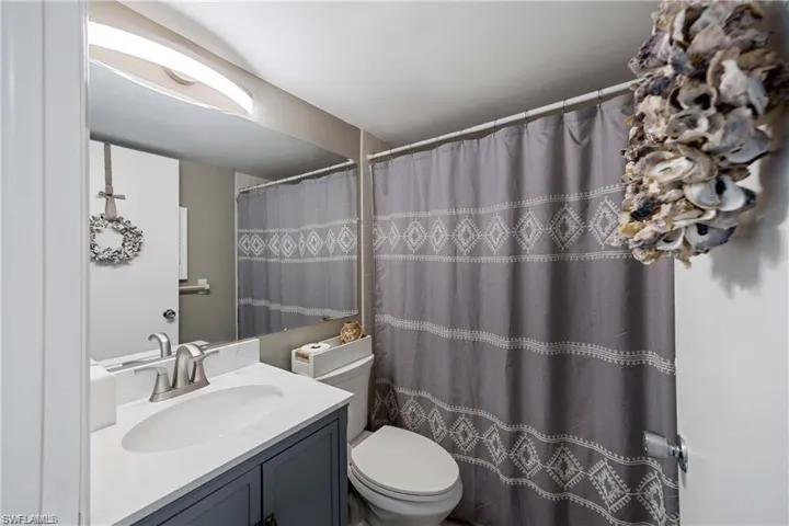 uest bathroom featuring a vanity with storage and a tub-shower combination.