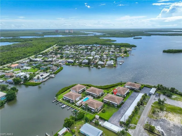 Waterfront aerial view featuring the condominium community bordered by canals and open waterways.