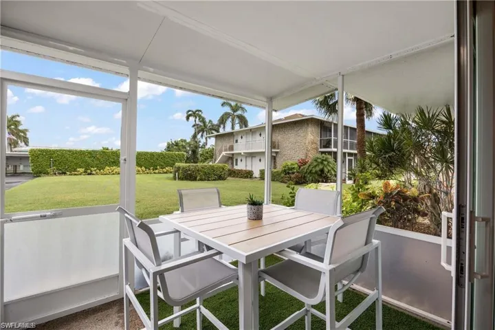 Screened lanai overlooking the landscaped courtyard, offering a comfortable outdoor living space.