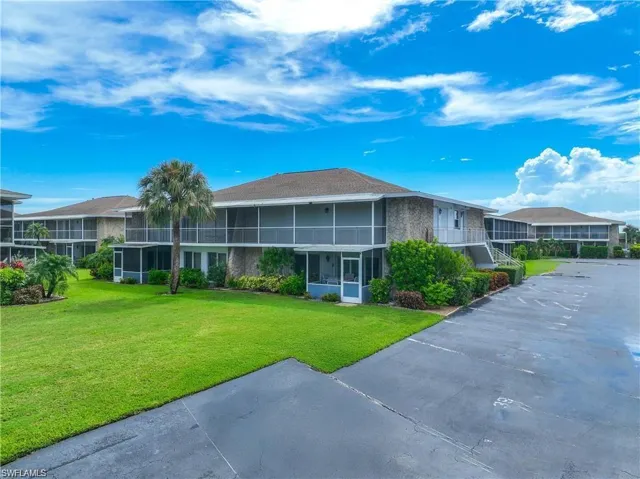 Well-maintained condominium buildings with tropical landscaping, open green space, and ample surface parking.