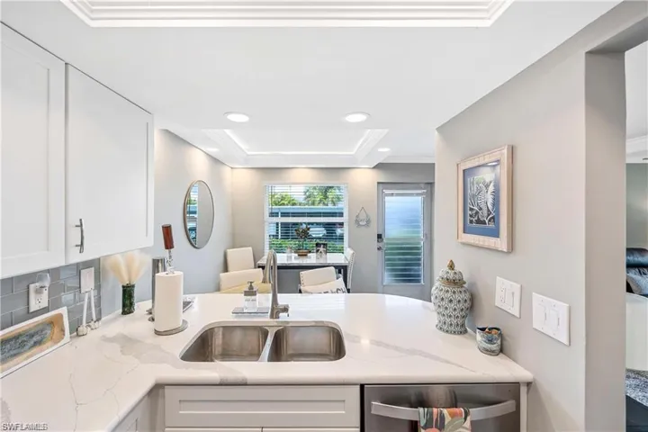 Updated kitchen with breakfast bar seating, quartz-style countertops, and an open view into the dining area.
