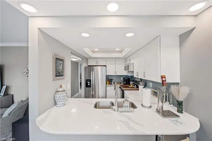 Kitchen with peninsula seating, double-basin sink, generous counter space, and an open view to the living area.