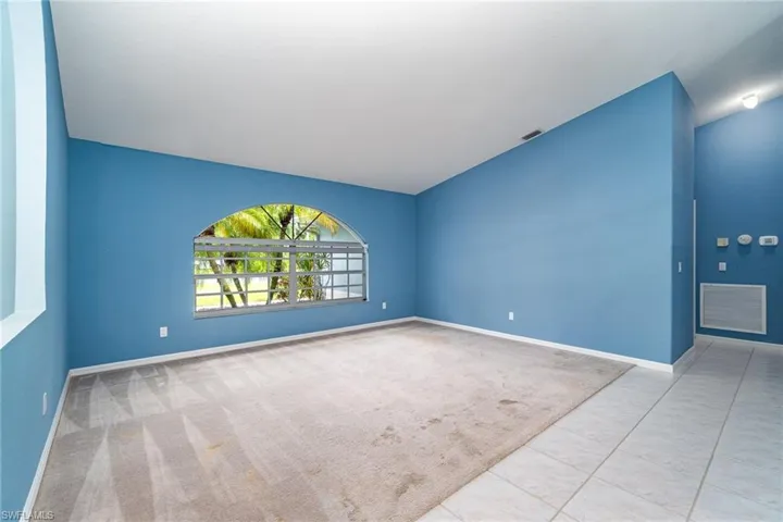 Open Front room with volume ceiling and views of front yard