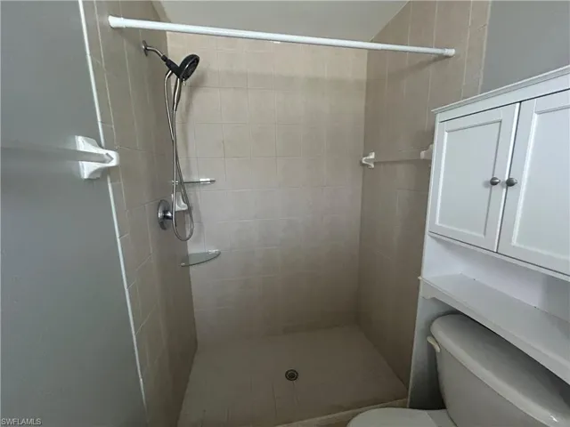 Full bath featuring toilet and a shower stall