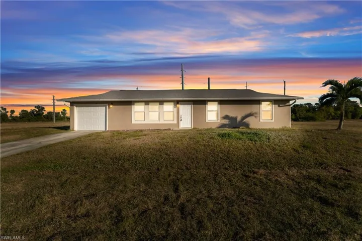 Single story home with a yard and a garage