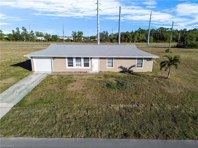 Ranch-style home with a front yard and a garage