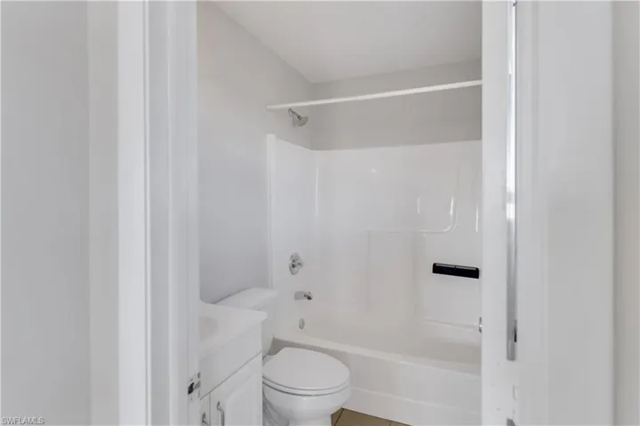Full bathroom with tile patterned floors, vanity,  shower combination, and toilet