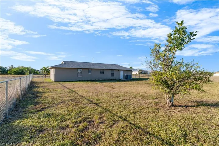 Rear view of house featuring a lawn