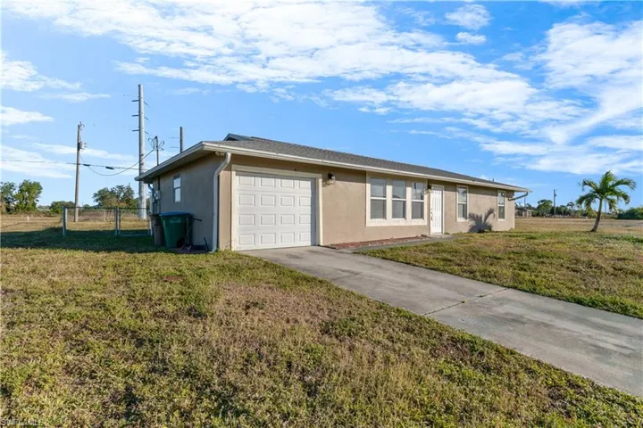 Single story home featuring a front yard and a garage