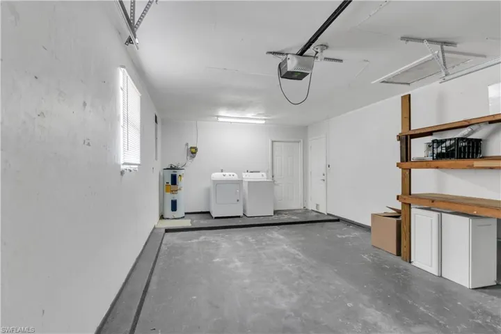Garage with water heater, washer and dryer, and a garage door opener