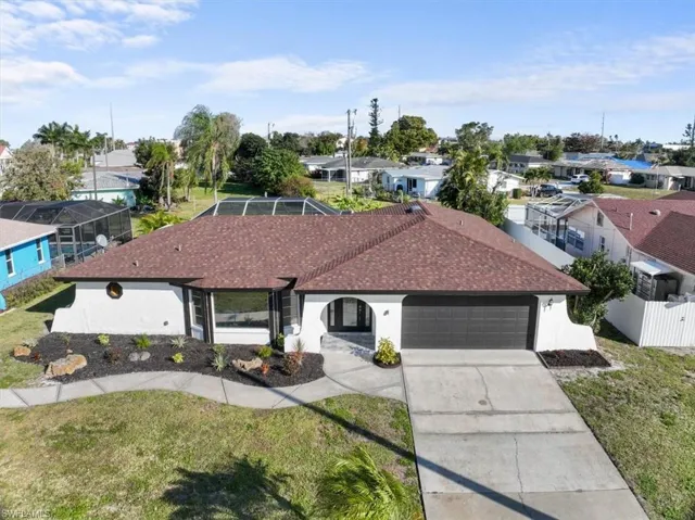 Ranch-style house with a front yard, concrete driveway, a garage, and a residential view