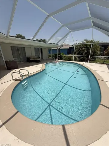 Outdoor pool with a sunroom, a patio area, and a lanai