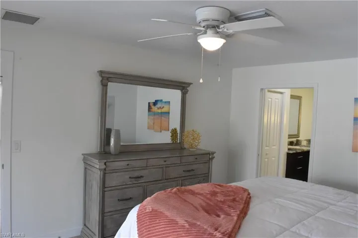 Bedroom featuring connected bathroom and a ceiling fan