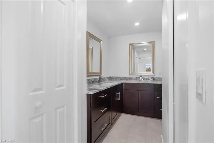 Full bath featuring double vanity, recessed lighting, and light tile patterned floors