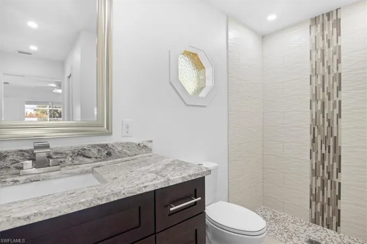 Full bathroom featuring vanity, a stall shower, and recessed lighting