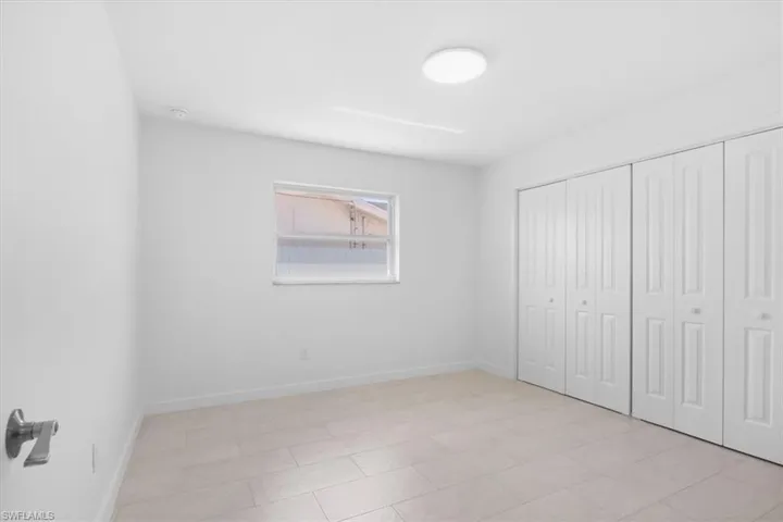 Unfurnished bedroom featuring a closet and light tile patterned floors